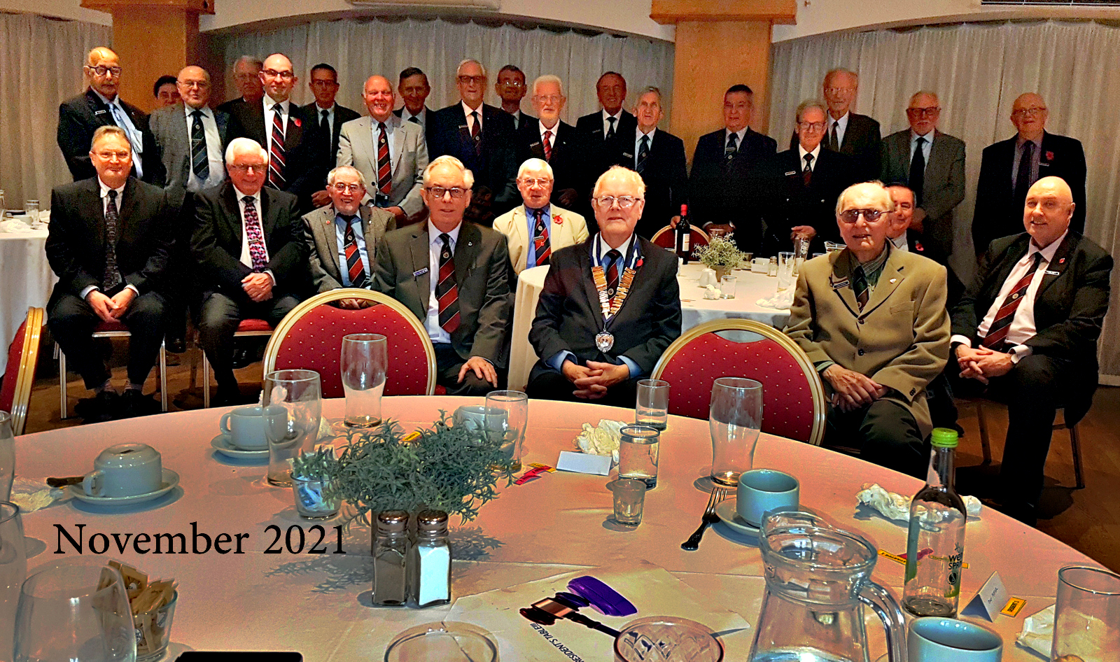 Standing left to right: Nick Martensz, Graeme Gribben, Alex Alexander, Dick Robson, Gerry Pye, Andrew Jude (guest), Ian Woods, Alan Voss, Clive Sprawson, Tim Clark, Tony Catterick, Colin Holdaway, Peter Joyner, Richard Barnett, Tony Pepper, Stephen Setchell, Jim Fisher, Brian Thomas.<br /> Seated left to right: Guy Evans, Peter Clark, Tom Mulchay, Bryan Basketter, Alistair Stewart, Alan Webb (President), David Heading, Chris Hall, Michael Burnham.<br /> Photograph taken after the Annual General Meeting on 2nd November 2021